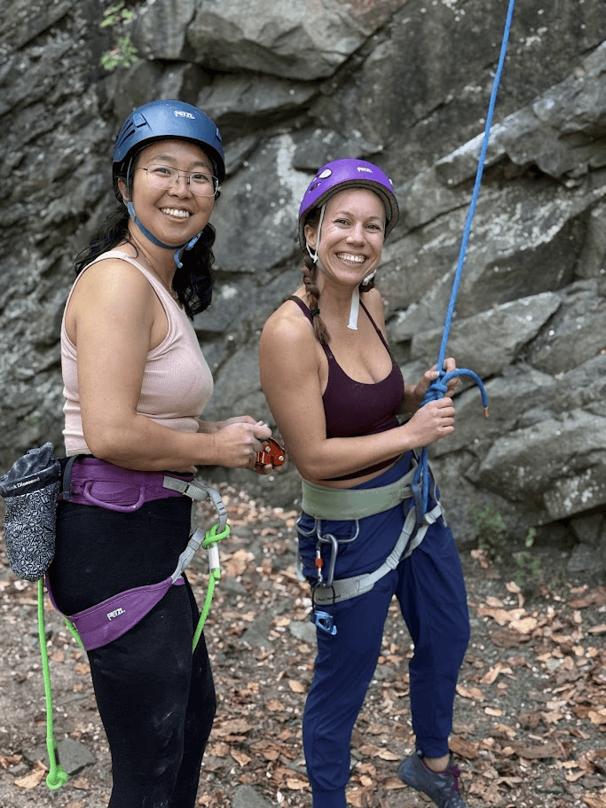 Two climbers gearing up at an outdoor crag